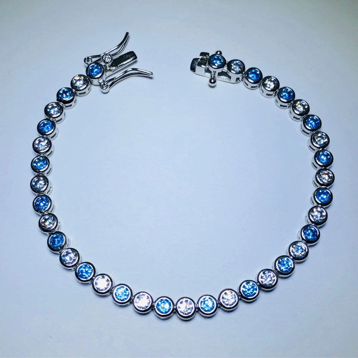LIV platinum over sterling silver blue & white sapphire bezel tennis bracelet 6” length